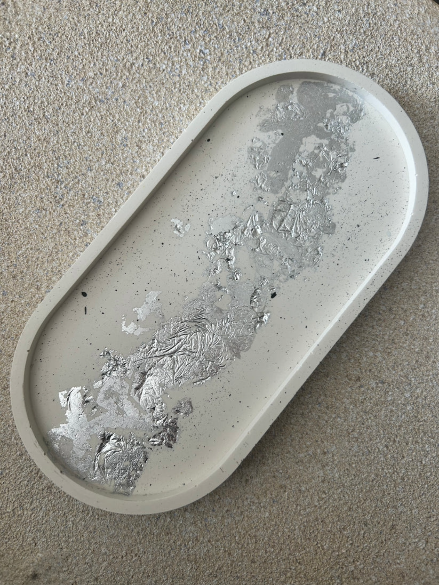 Handmade Home Accessories - A Large oval cream trinket tray with black splatters and silver leaf detail. This shows the full tray at a 45 degree angle.