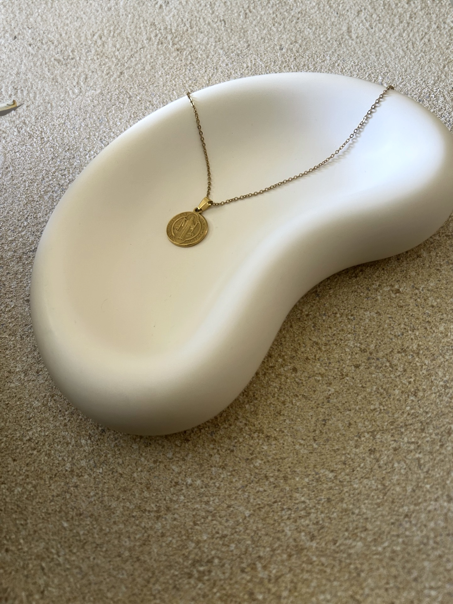 Handmade Home Accessories - an angled photo of a white jelly bean style chunky trinket tray with a gold coin necklace displayed on it