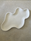 Handmade Home Accessories - a plain full shot of a cream wavy style trinket tray with black splatters