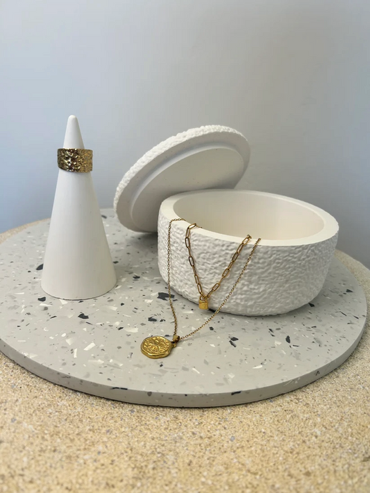 Handmade Home Accessories - a grey terrazzo style display plate showing a ring holder with a gold ring on and a boucle type pot with two gold necklaces draping out, used to display the size of the tray.