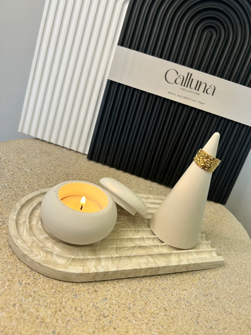 Handmade Home Accessories - a photo of the smallest arch tray in a beige marble finish with a tealight holder and a ring holder on holding a gold ring.