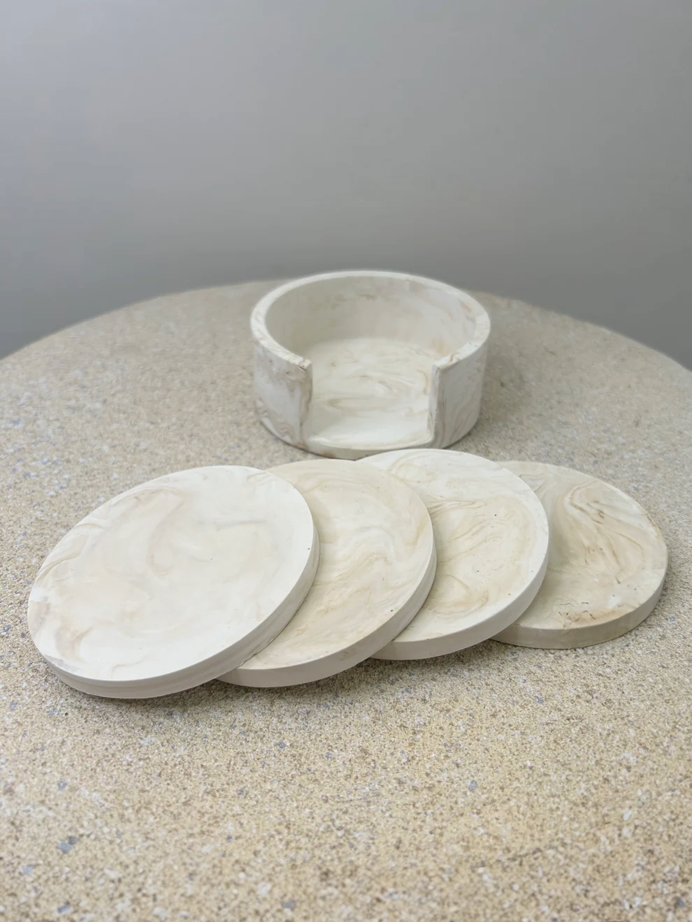 Handmade Home Accessories - am image of a coaster holder, with four coasters in front in a beige marble design