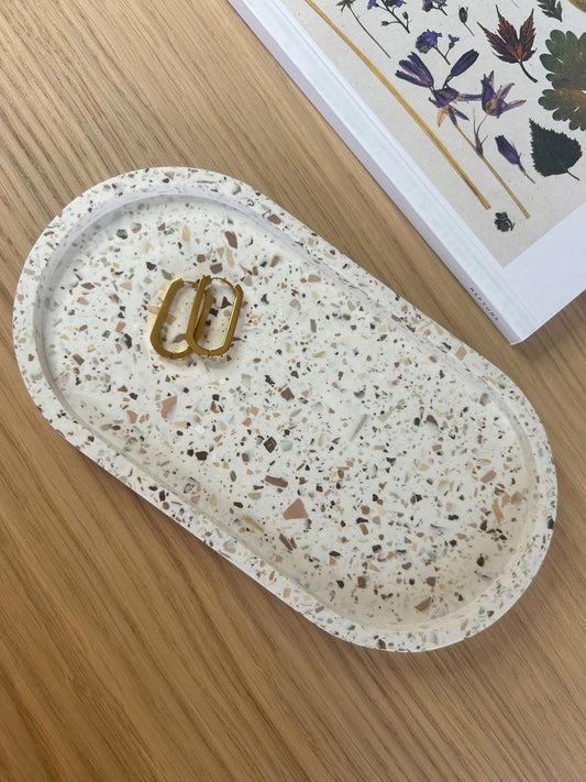White terrazzo oval tray with gold earrings – handcrafted home accessory for jewellery or keys in modern interiors.