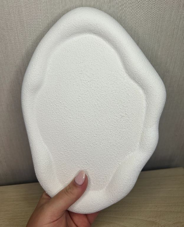 Handmade Home Accessories - Pure white textured pebble trinket tray, held up by a hand wearing pale pink nail varnish. The photo is taken vertically and front on.