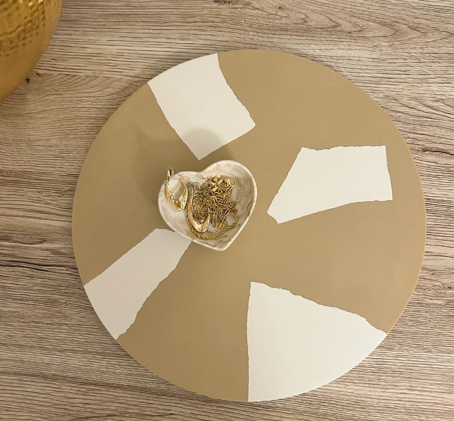 Handmade Home Accessories - a beige snp tray on a darker wooden background displaying a marble heart trinket dish that has gold jewellery in