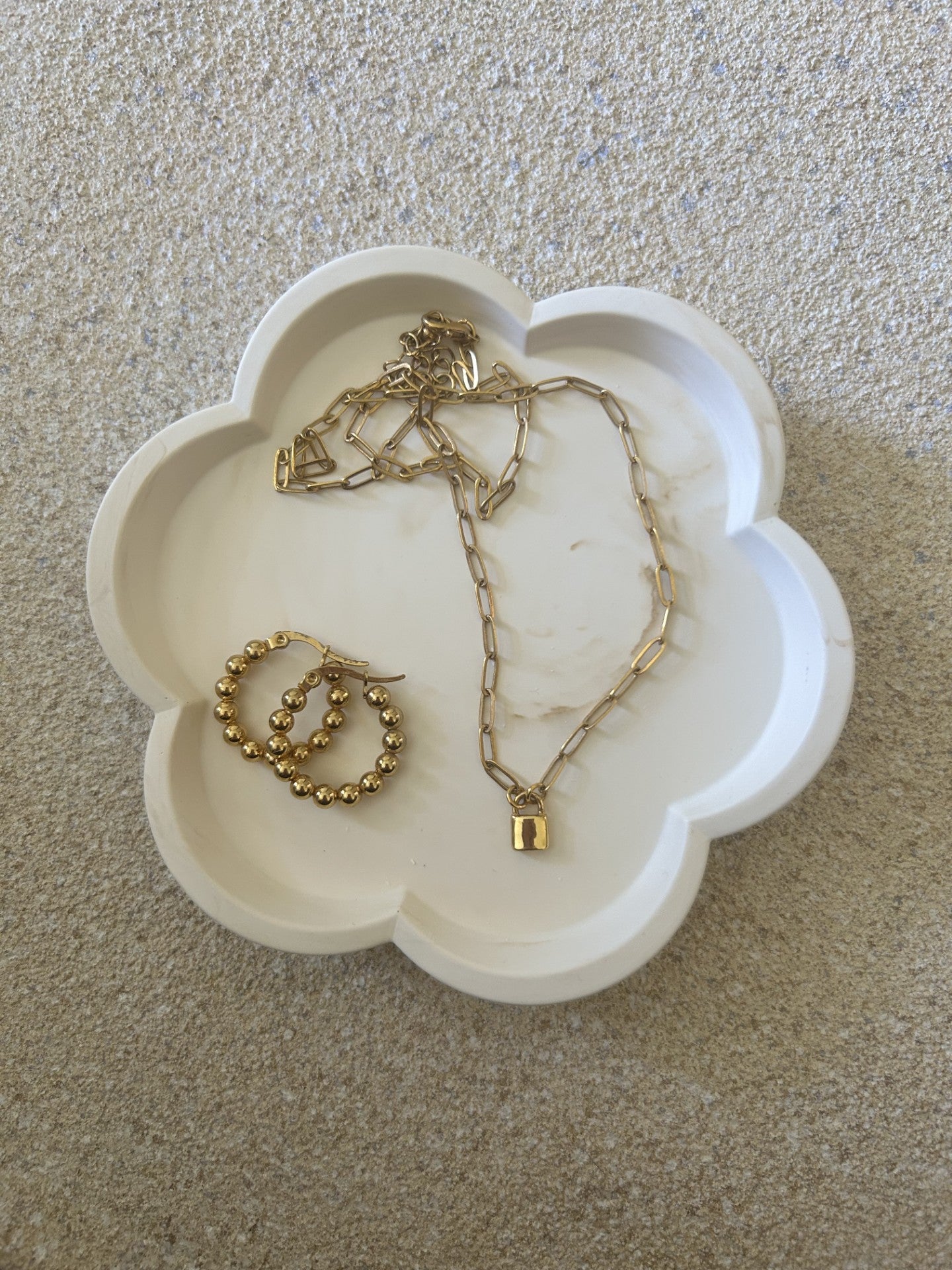 Handmade Home Accessories - a brown marble flower shaped trinket tray with a gold lock necklace and bubble gold hoops on