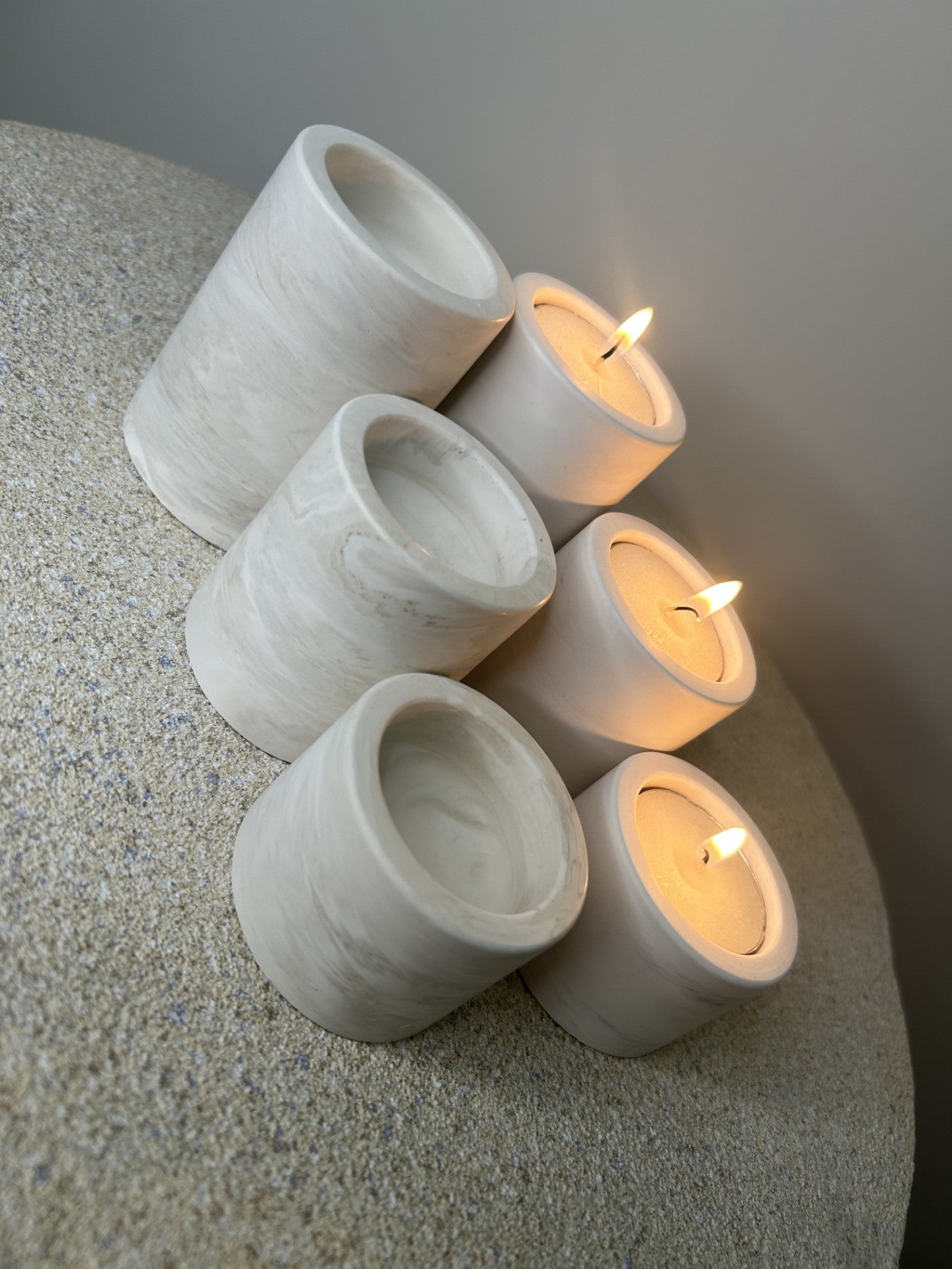 Handmade Home Accessories - six griege and grey marble candle holders showing differing heights.