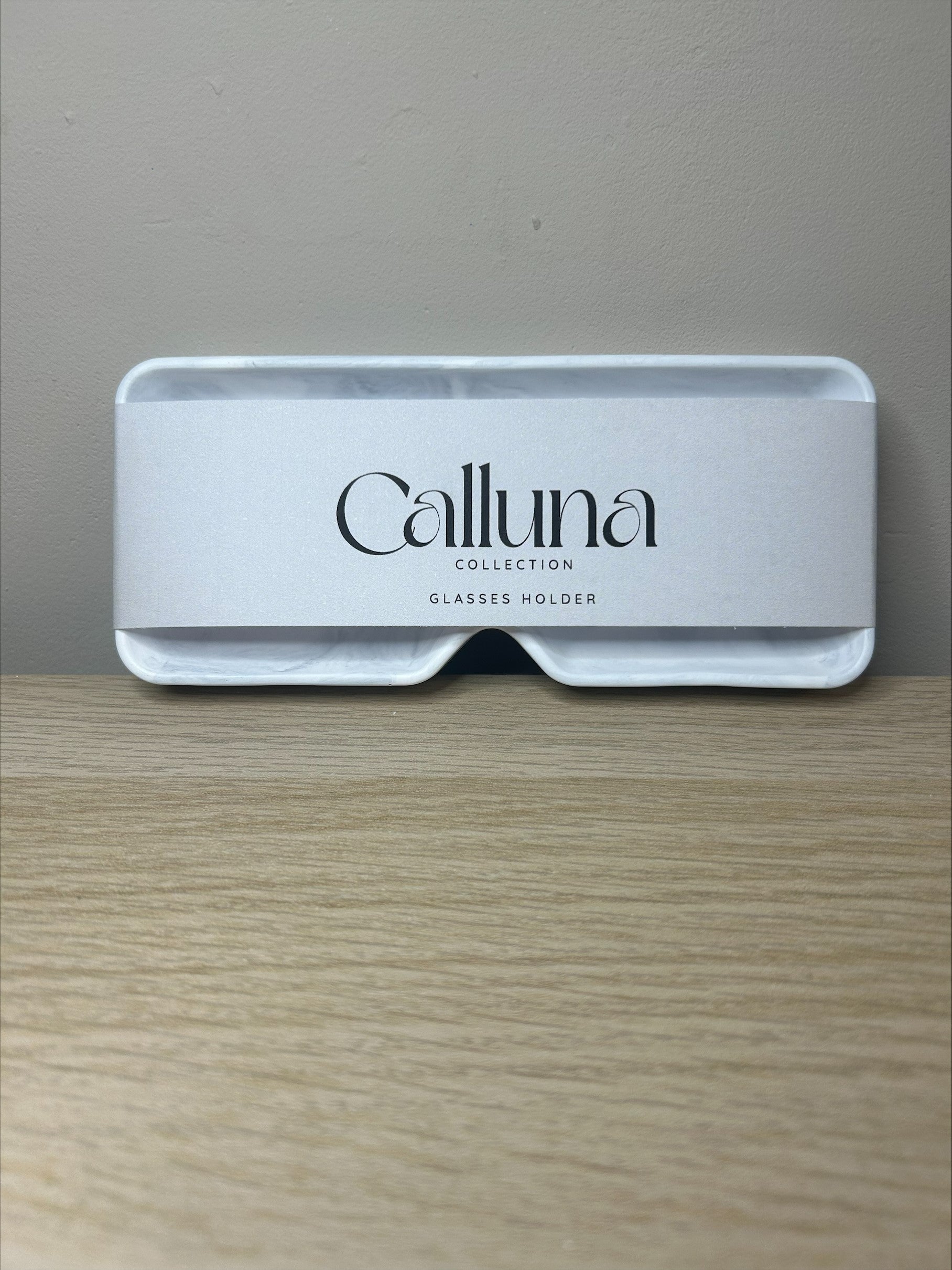 Handmade Home Accessories - one grey marble square glasses tray, sat against a brown wall on a wooden surface with a belly band around stating the company name Calluna Collection.