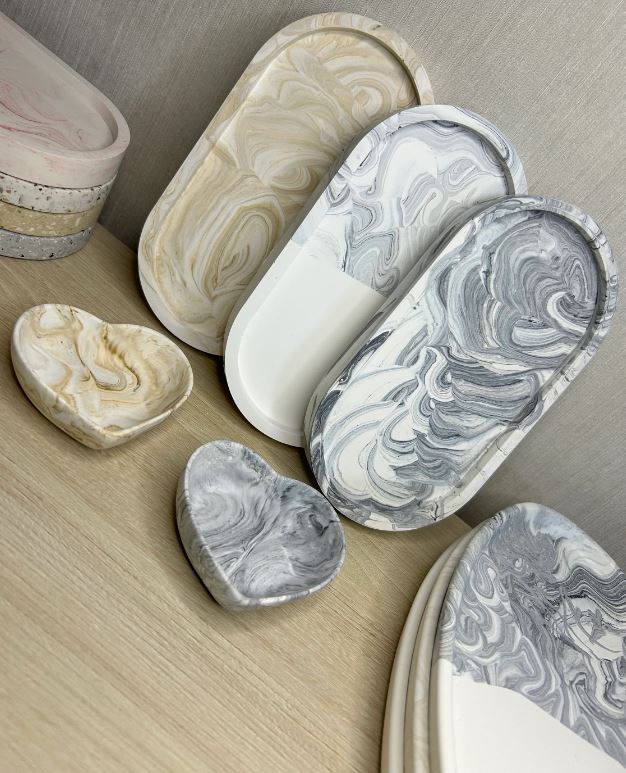 Handmade Home Accessories - a display of three oval trinket rays positioned against a wall, with two marble heart dishes in front. 